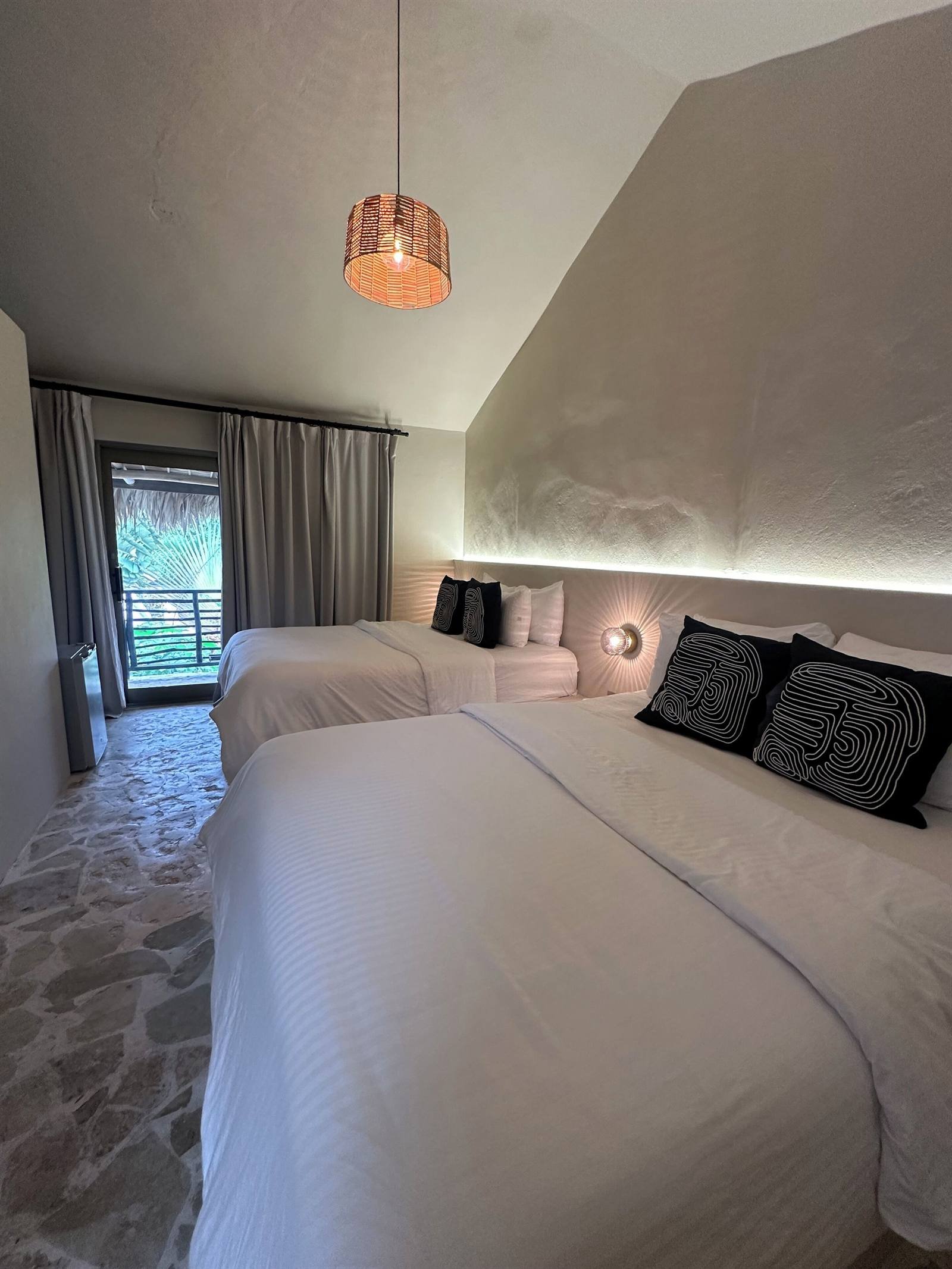 El Rincón de Abi: Deluxe double room with two queen beds and a copper pendant lamp